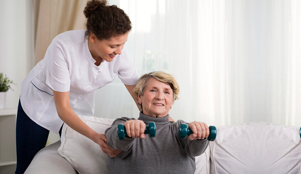 caregiver assisting senior woman physical therapy
